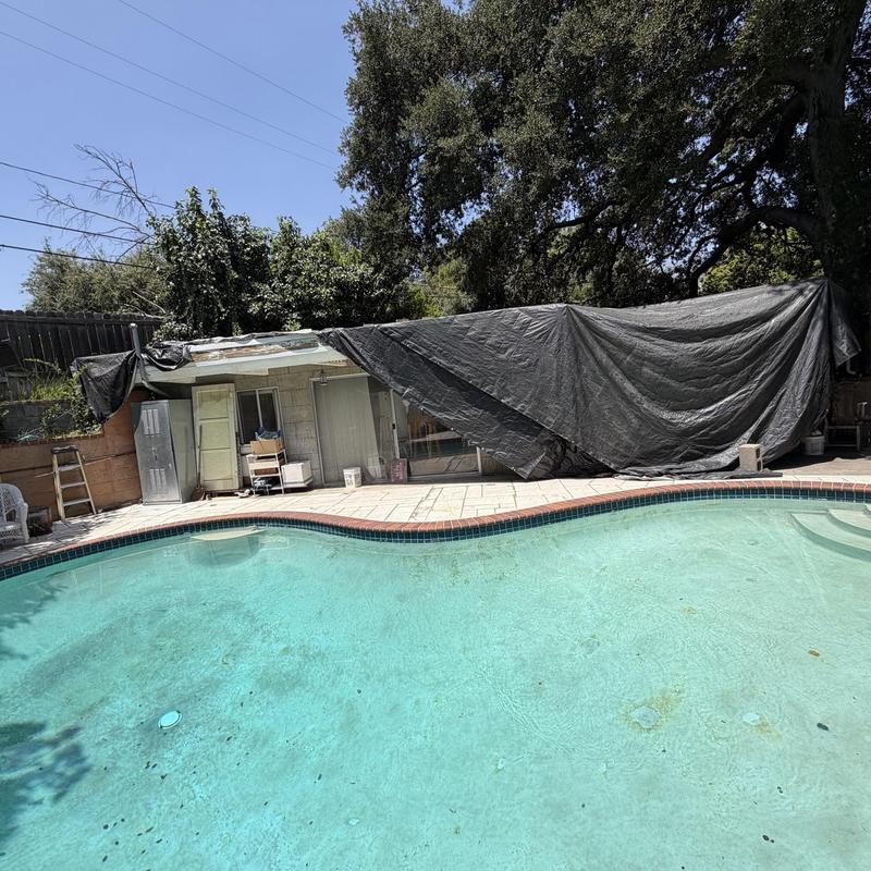 Flat roof covered with tarp by swimming pool Flat roof covered with tarp by swimming pool