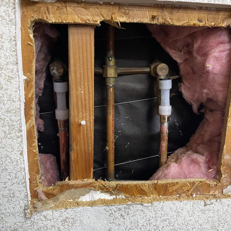 Two-handle shower valve cartridge plumbing behind wall