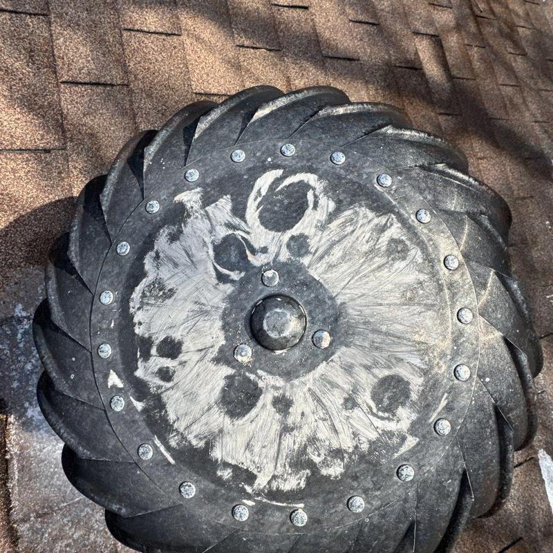 Roof turbine vent with hail damage on shingles
