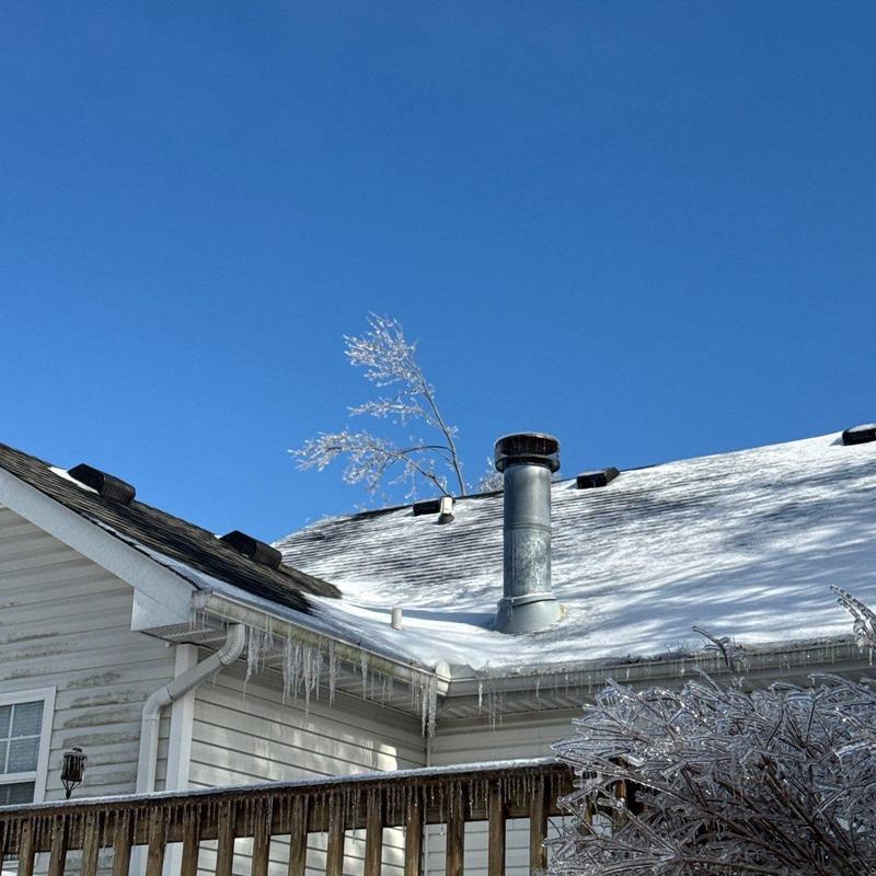 Shingles and chimney with ice accumulation on roof