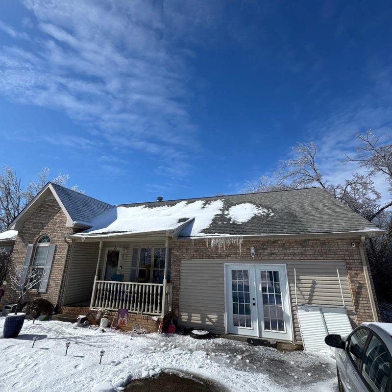 Roofing system with snow and ice buildup on shingles