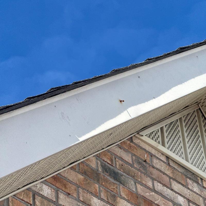 Roof edge and fascia with visible nail rust and wear