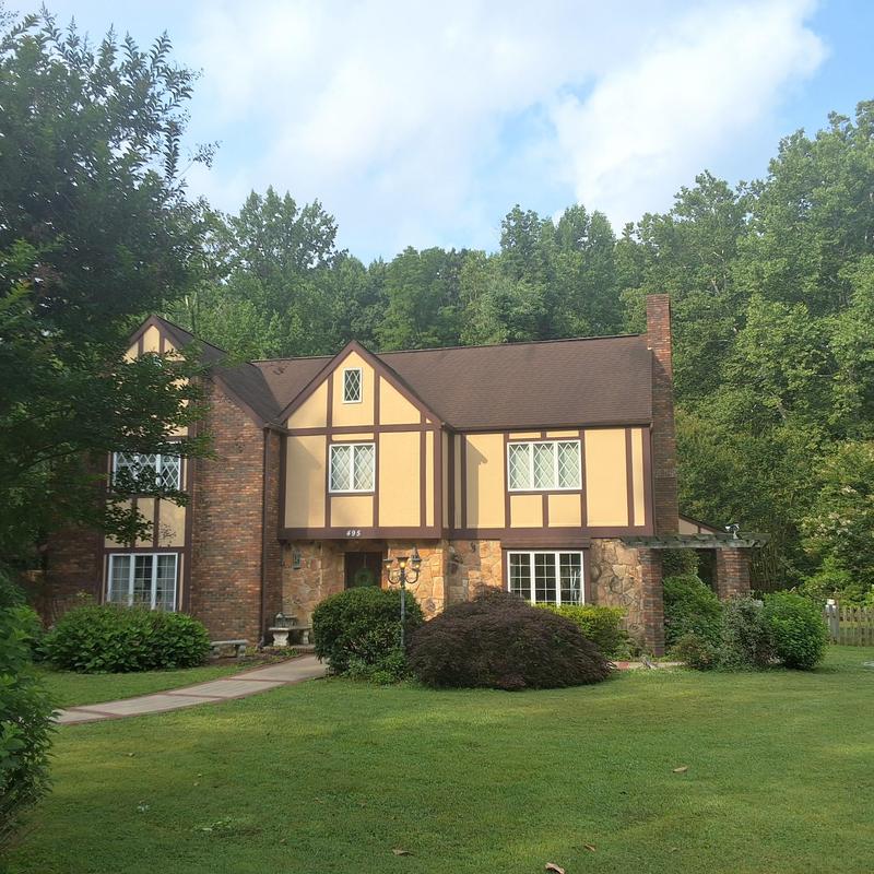 Asphalt shingle roof on Tudor-style home with aging wear Asphalt shingle roof on Tudor-style home with aging wear