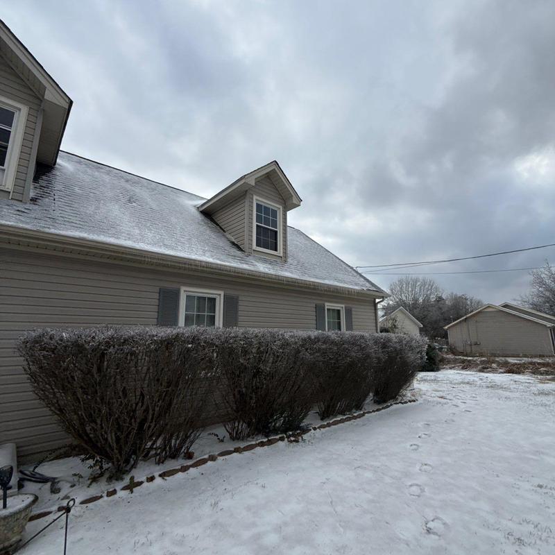 Roof shingles with light snow and frost on residential house