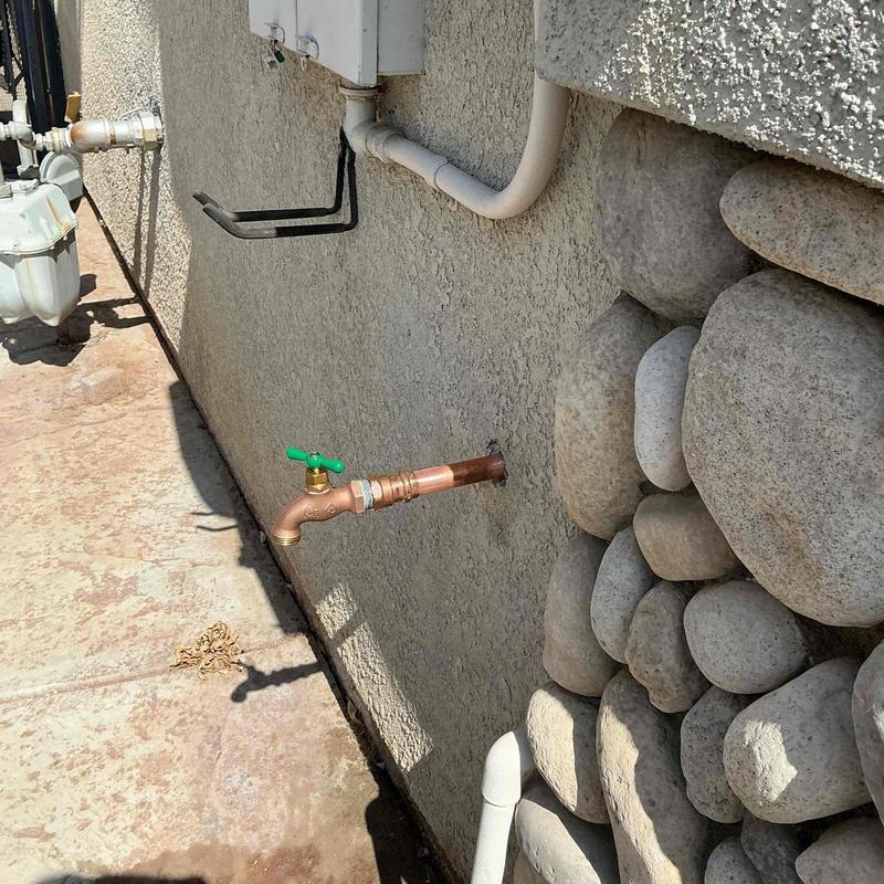 Threaded hose bib and copper piping on exterior wall