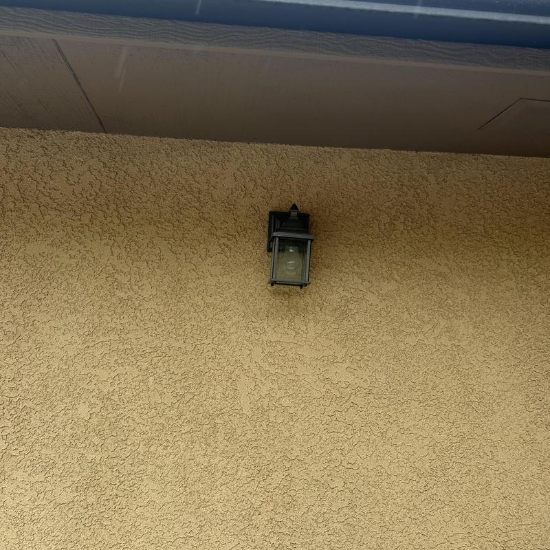 Outdoor wall light fixture on stucco wall