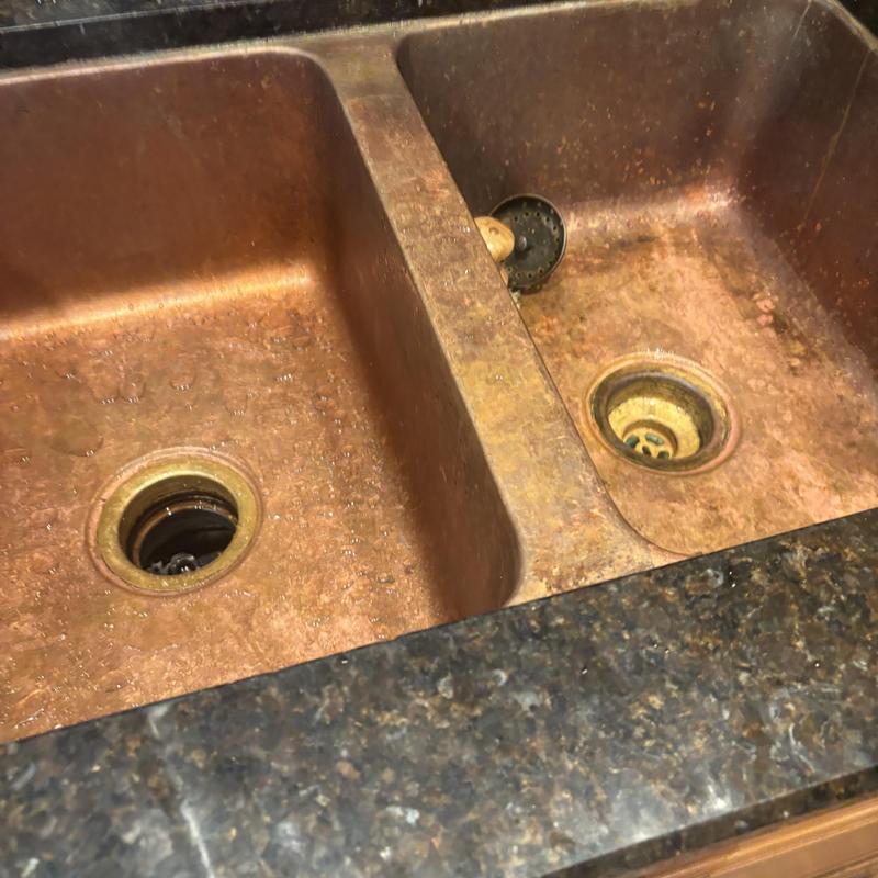 Copper kitchen sink drain openings with debris buildup