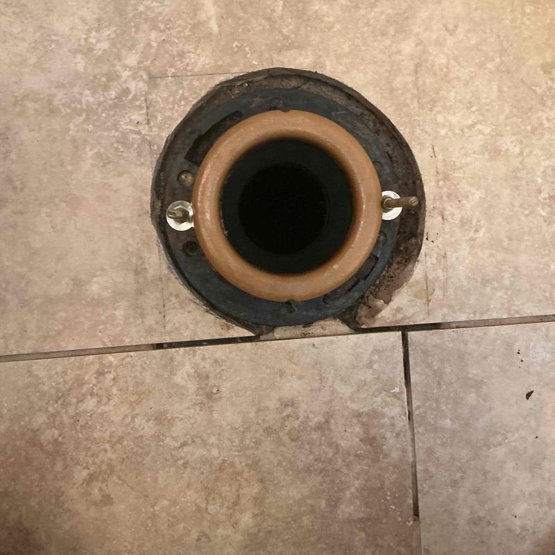 Toilet flange with new wax ring on tiled floor