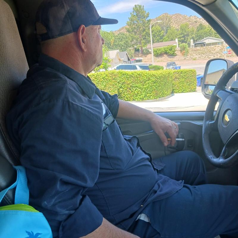 Plumber in work uniform inside service vehicle cabin