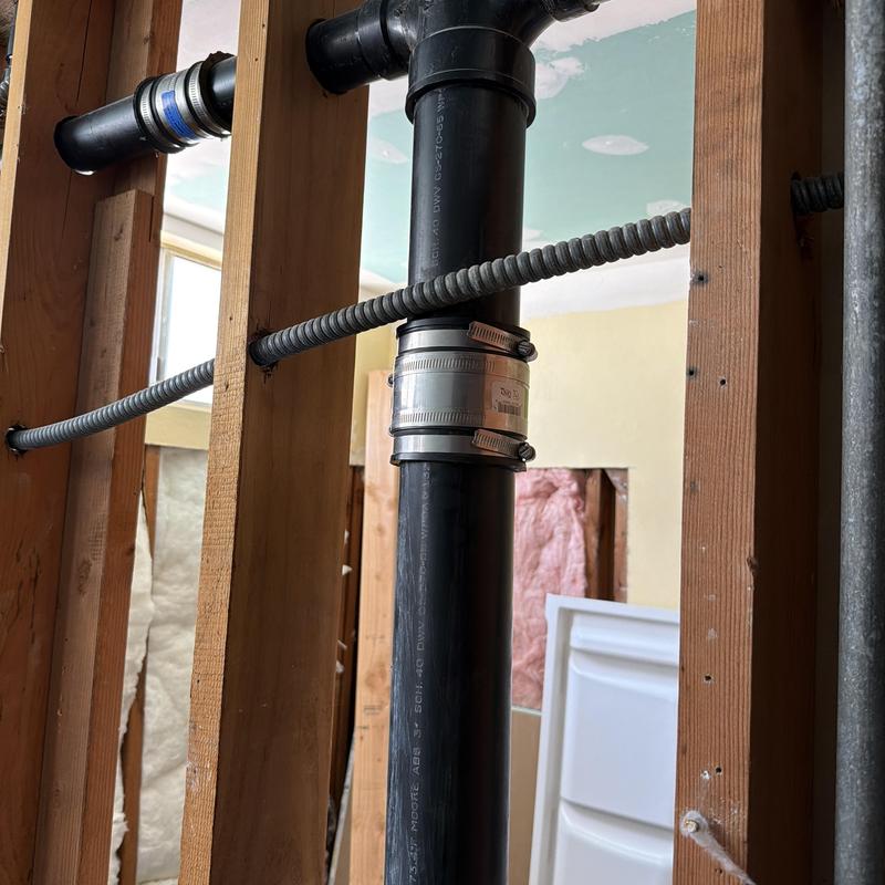 Sewer stack pipe with metal band clamp repair Sewer stack pipe with metal band clamp repair