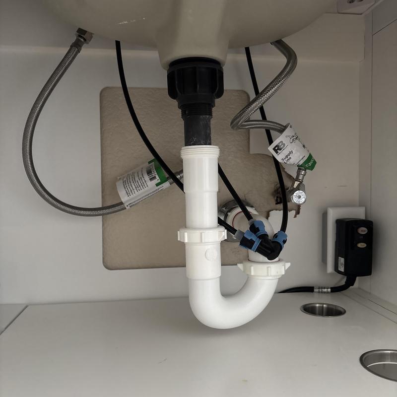 Sink drain pipe with water supply lines under cabinet