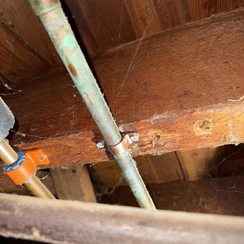 Copper water lines secured with pipe straps in ceiling