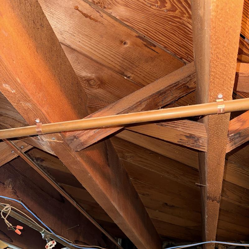 Copper water lines secured with pipe straps in attic