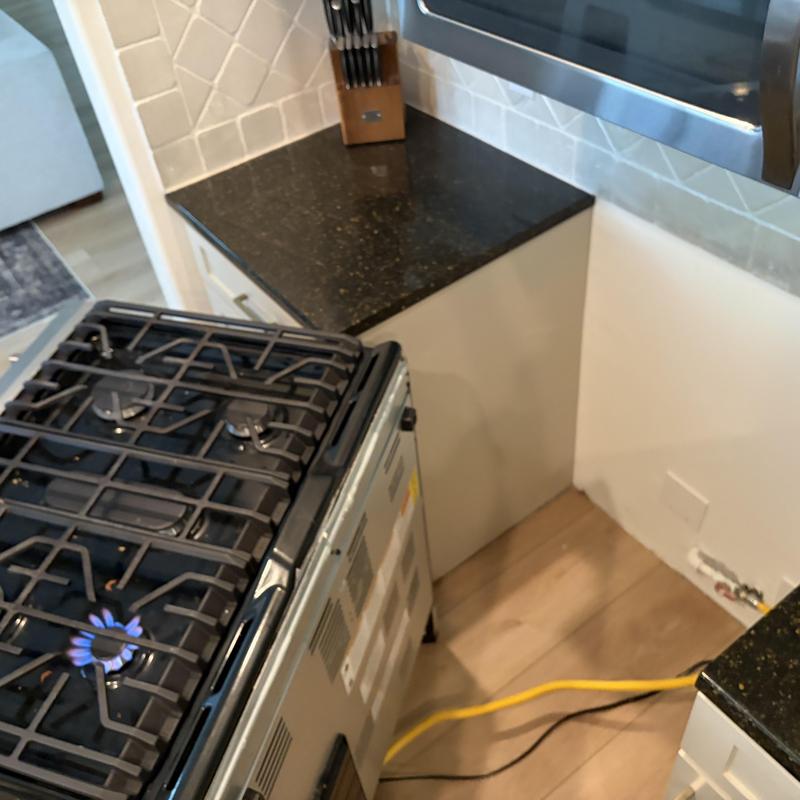 Gas stove burner with flexible gas connector and flame on