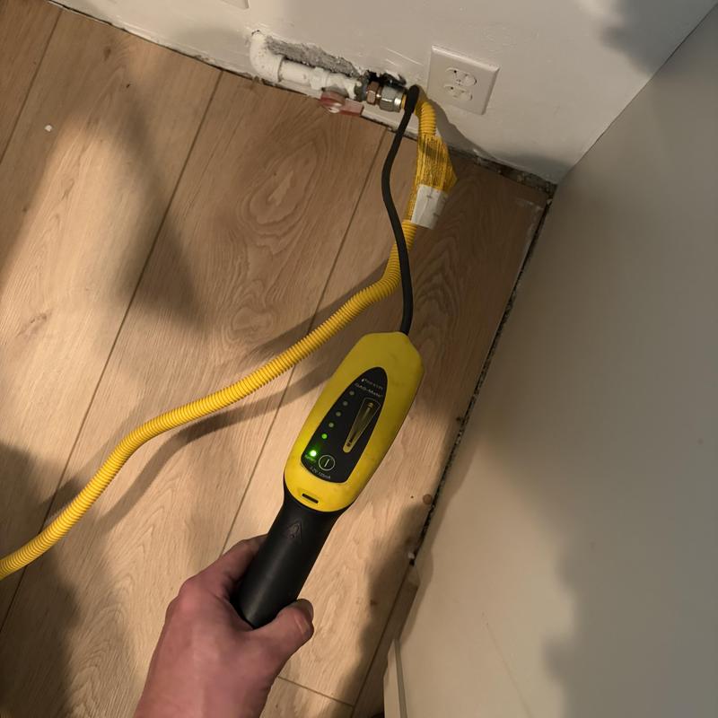 Gas stove flexible connector leak detection tool in use