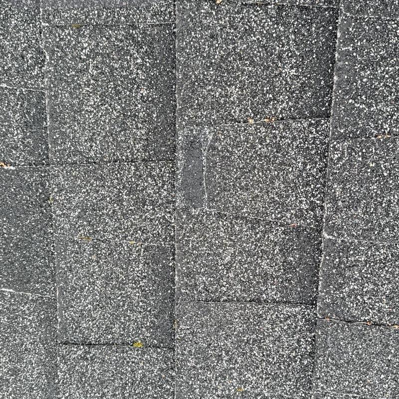 Asphalt roof shingles close-up showing granule wear