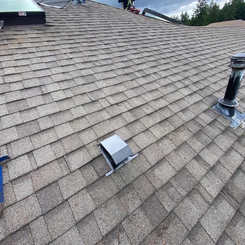 Flapper vent and skylight on asphalt shingle roof