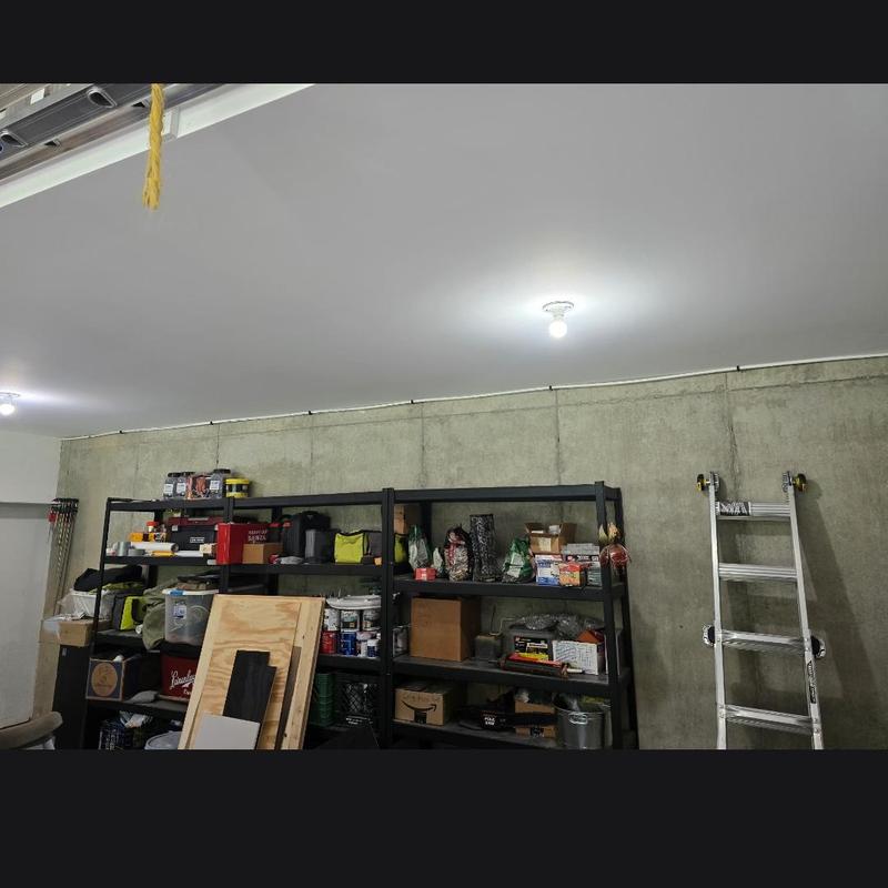 garage shelving and ladder storage setup in concrete wall space