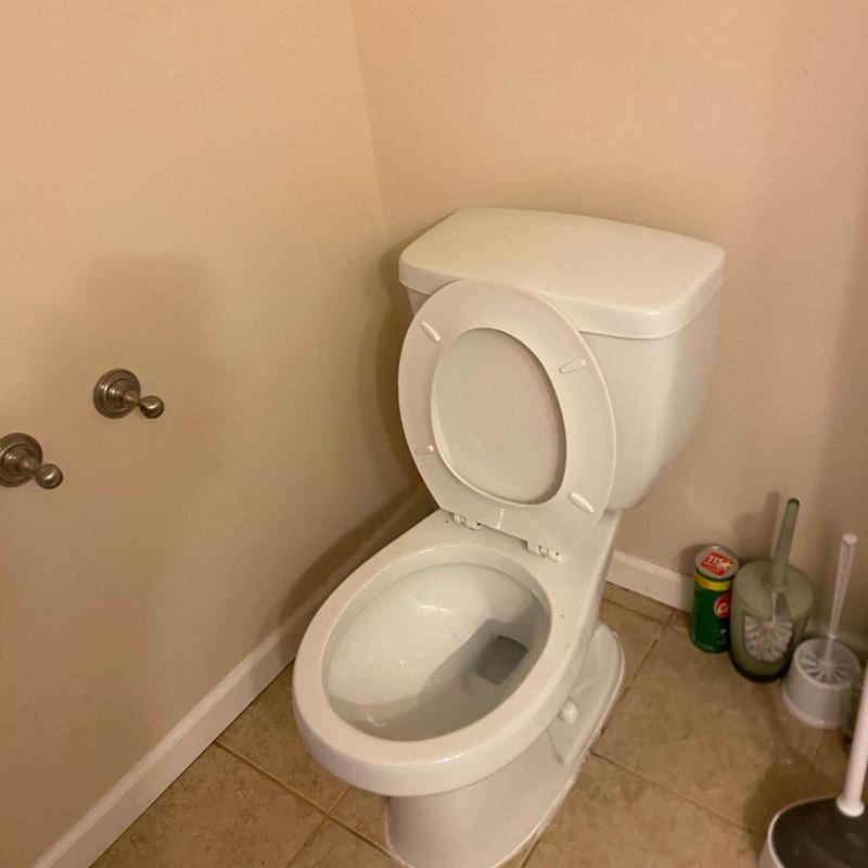 Toilet with removed obstruction and reset seat in bathroom