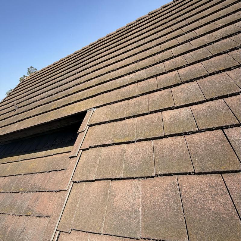 Flat tile roof with no visible damage under clear sky Flat tile roof with no visible damage under clear sky