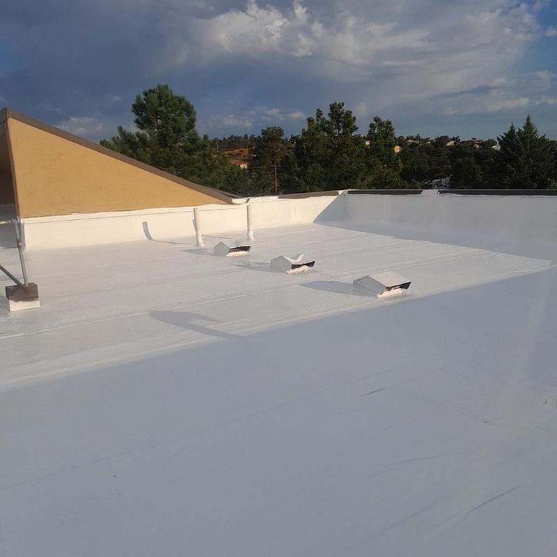 Flat roof membrane with vent covers and surrounding trees Flat roof membrane with vent covers and surrounding trees