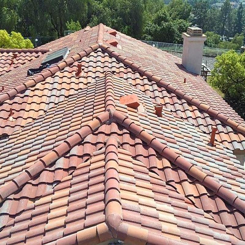 Tile roofing system with ridge caps on residential roof Tile roofing system with ridge caps on residential roof