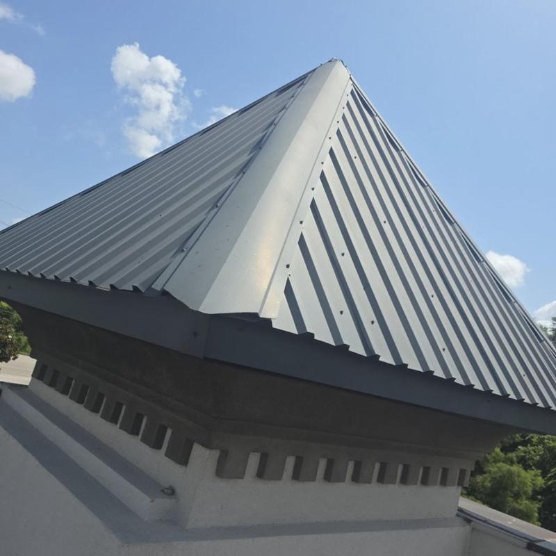 Metal roof cap flashing on commercial building peak