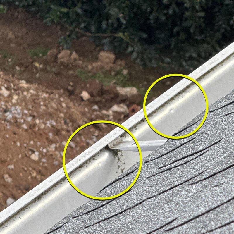 Metal gutter with hail damage dents and marks highlighted
