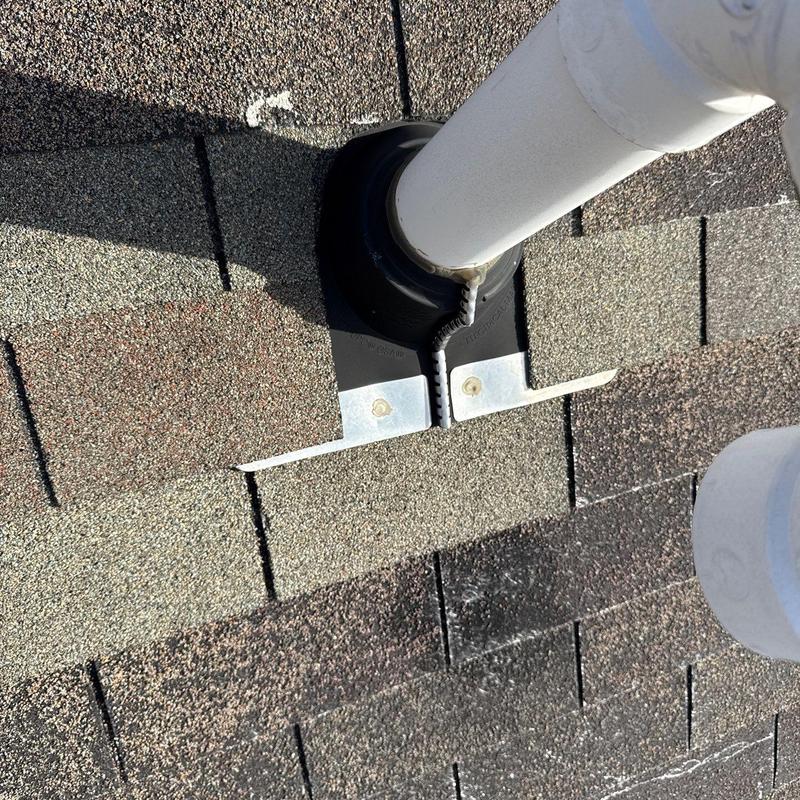 Roof pipe flashing with hail-damaged shingles