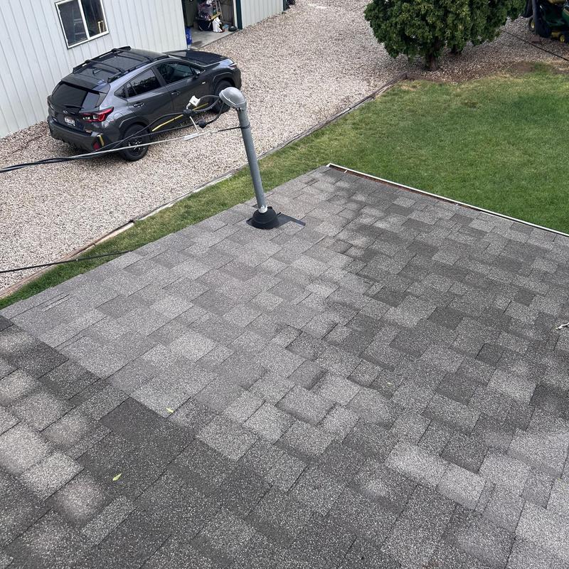 Asphalt shingle roof with vent pipe and surrounding yard