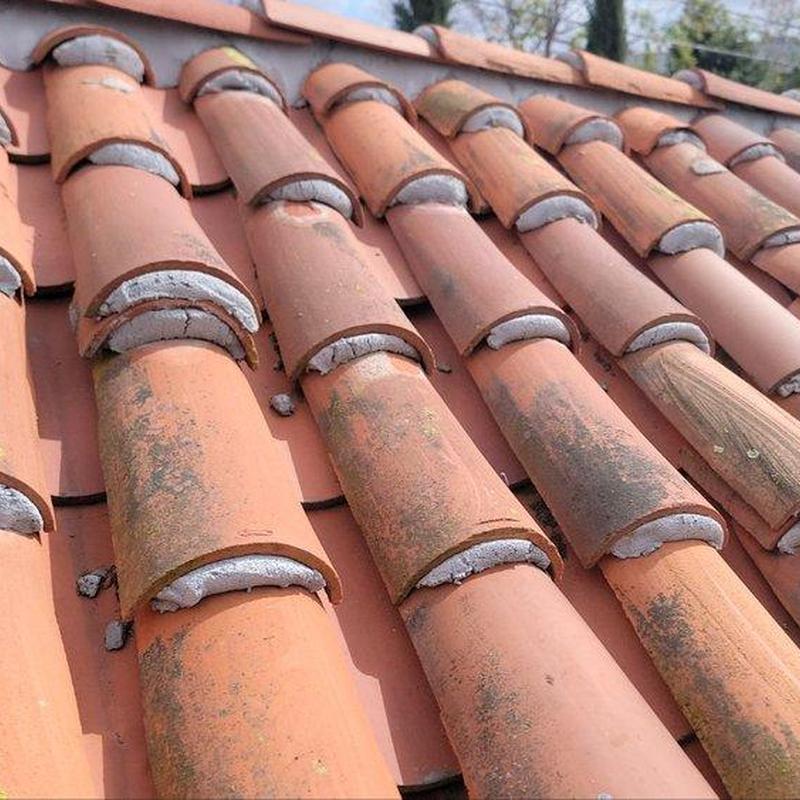 Tile roofing with sealed ridge caps and mortar repair Tile roofing with sealed ridge caps and mortar repair