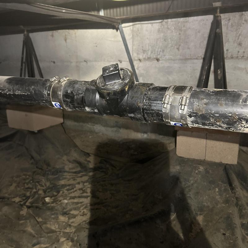 Mainline sewer pipe with cleanout installation in crawl space Mainline sewer pipe with cleanout installation in crawl space