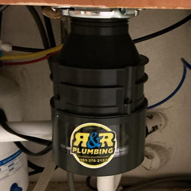 Garbage disposal unit under kitchen sink with plumbing