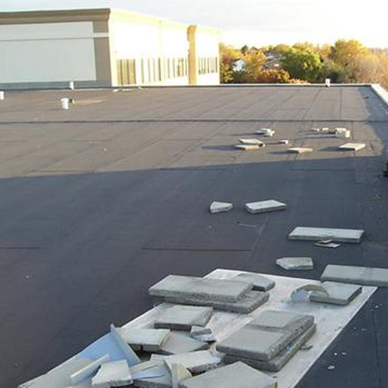 Commercial flat roofing with scattered debris on surface Commercial flat roofing with scattered debris on surface