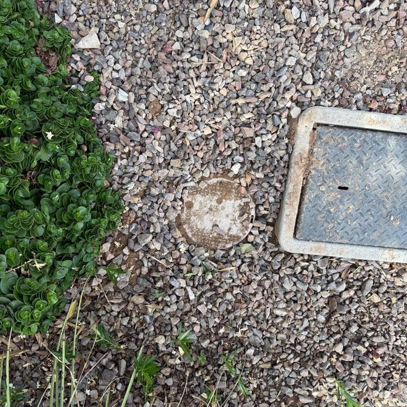 Pressure reducing valve access box and meter cover surrounded by rocks