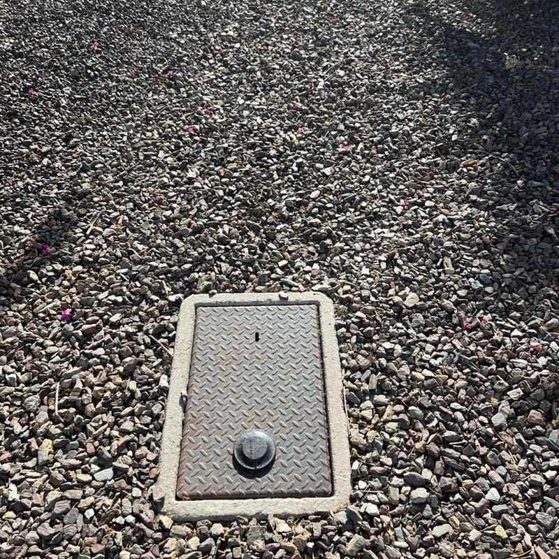 Pressure reducing valve covered by landscaping valve box in gravel