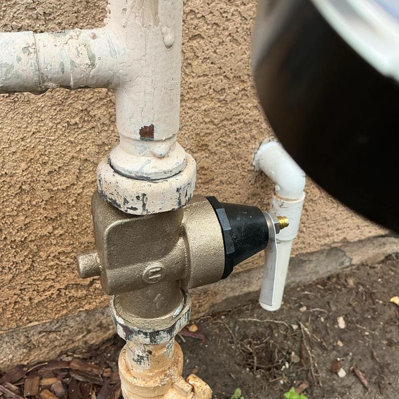 Pressure regulator valve on outdoor plumbing pipe