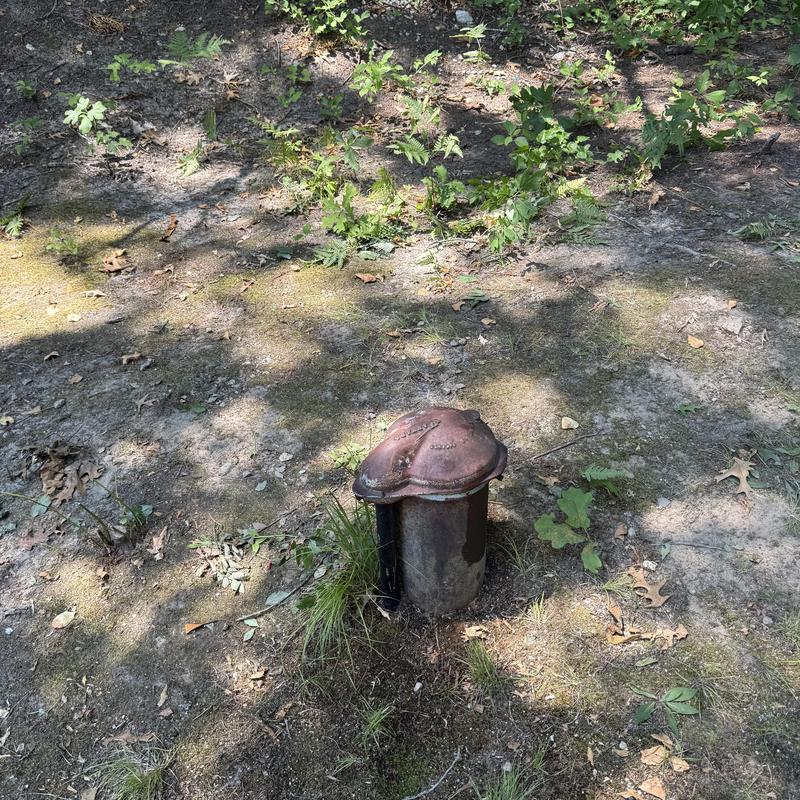 Well pump casing in outdoor ground setting Well pump casing in outdoor ground setting