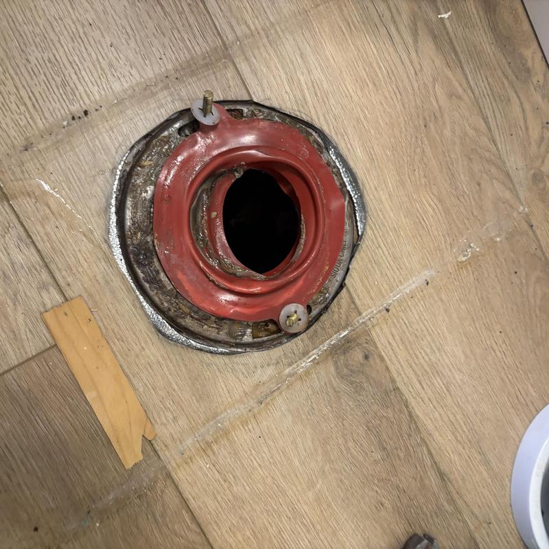 Toilet flange installed on wood floor prior to toilet installation