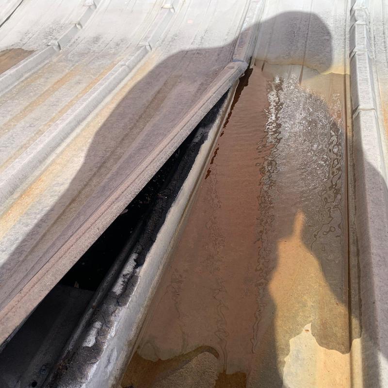 Metal roof panel with rust and water pooling