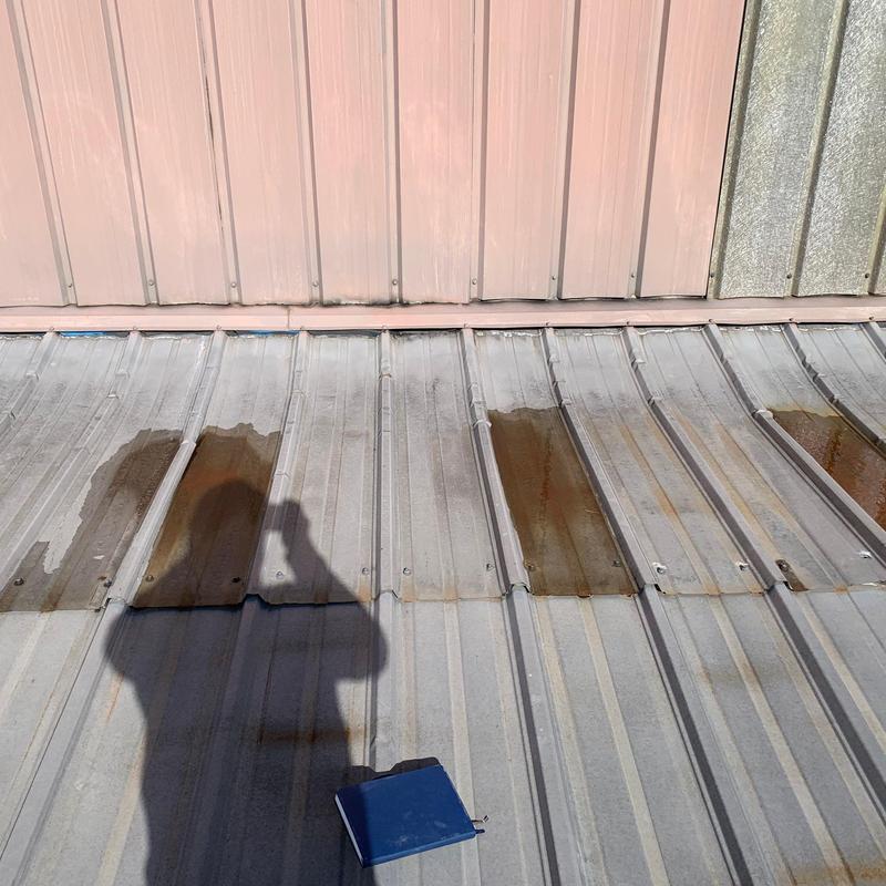 Metal roof panels with rust patches and fasteners