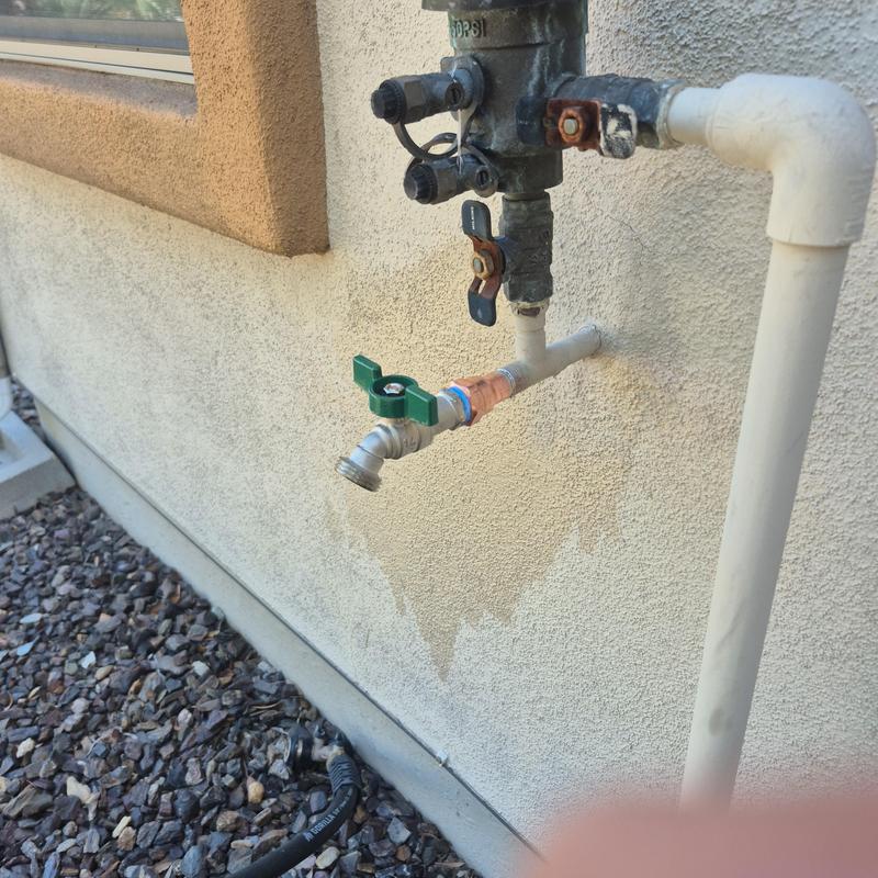 Outdoor hose bib with green valve handle installation