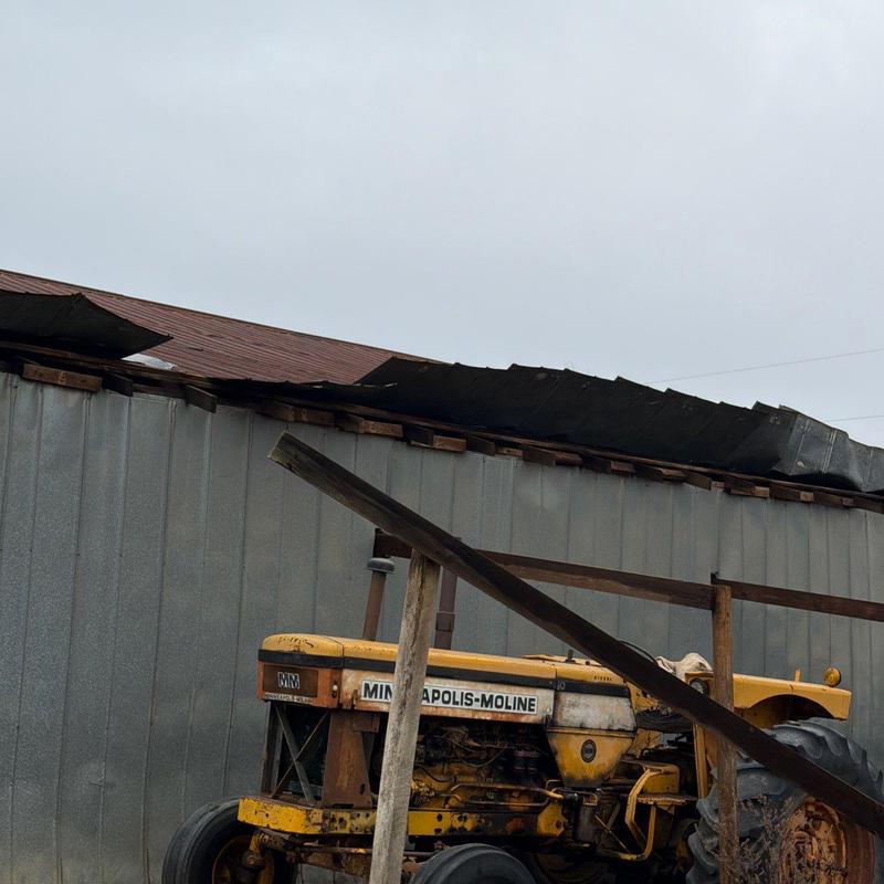 Barn metal roofing with visible hail damage and torn panels