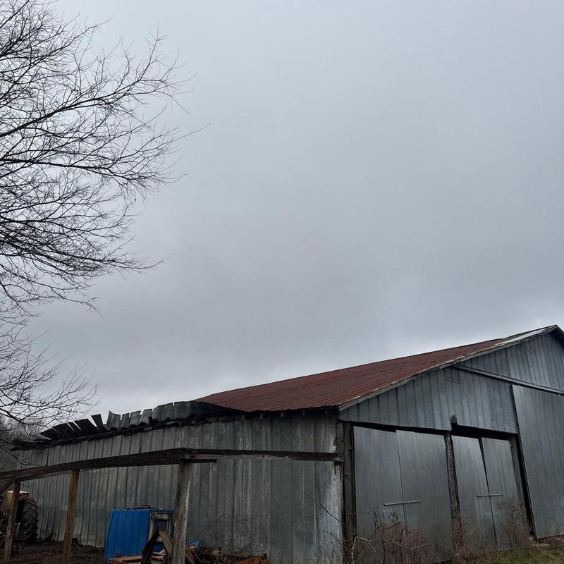 Barn metal roof with visible hail damage and wear