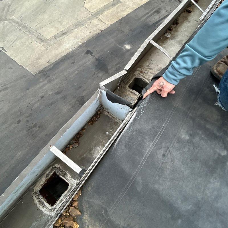 Roof gutter flashing damage inspection on flat roof