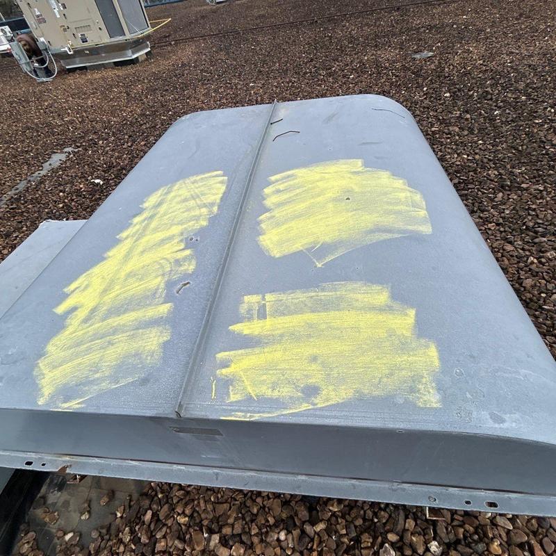 Metal roof vent with yellow chalk markings for repair