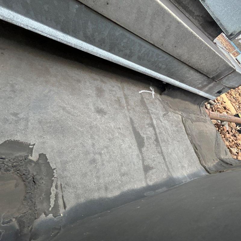 Flat rubber roof membrane with hail damage and repairs