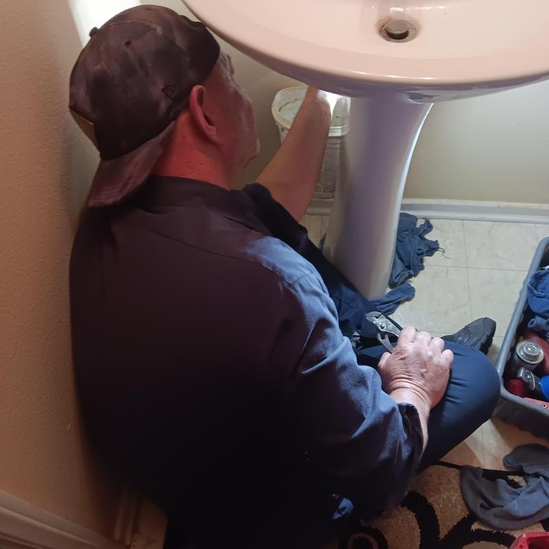 Pedestal sink plumbing with plumber using wrench