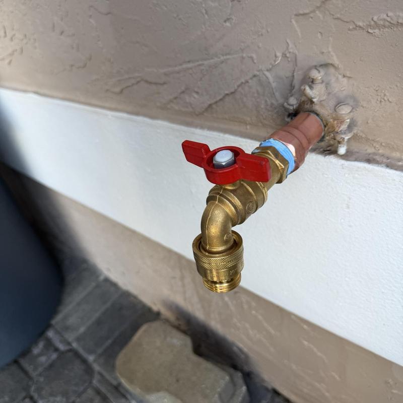 Outside hose bib with red valve handle installed