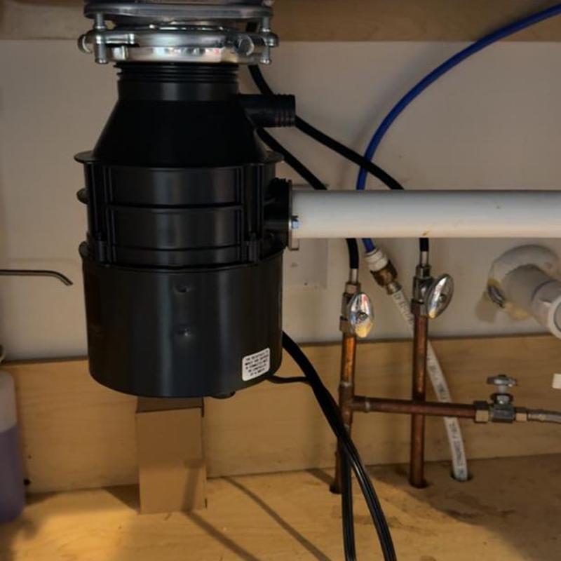 Garbage disposal unit with connected plumbing pipes